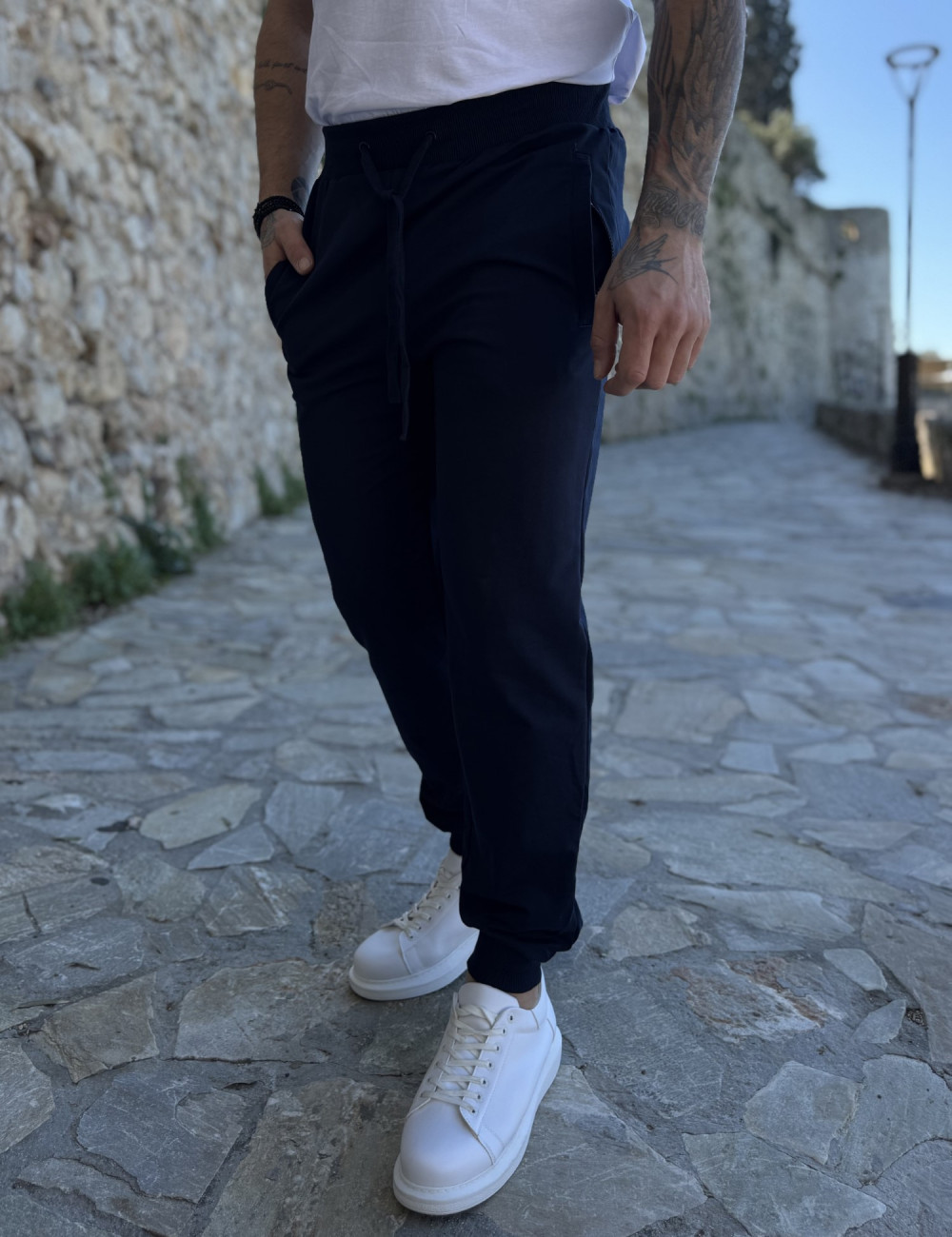 Ανδρική αθλητική φόρμα με τσέπες που κλείνουν με φερμουάρ.