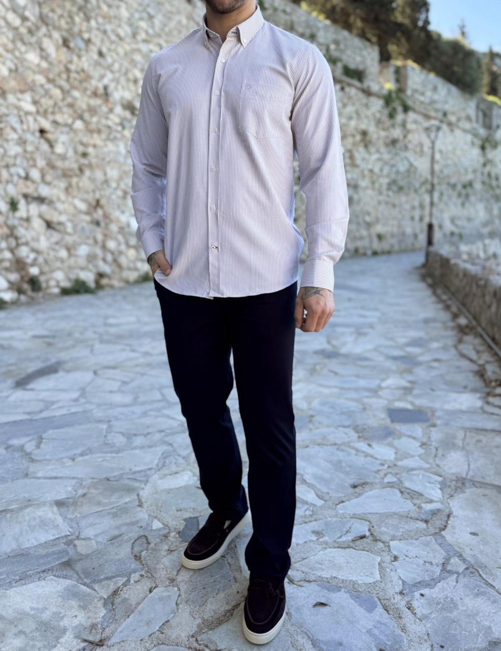 Ανδρικό πουκάμισο που διαθέτει γιακά κολάρο, κλείσιμο με κουμπιά, έχει ανάγλυφο σχέδιο με το λογότυπο της εταιρείας πάνω στην τσέπη του στήθους.
