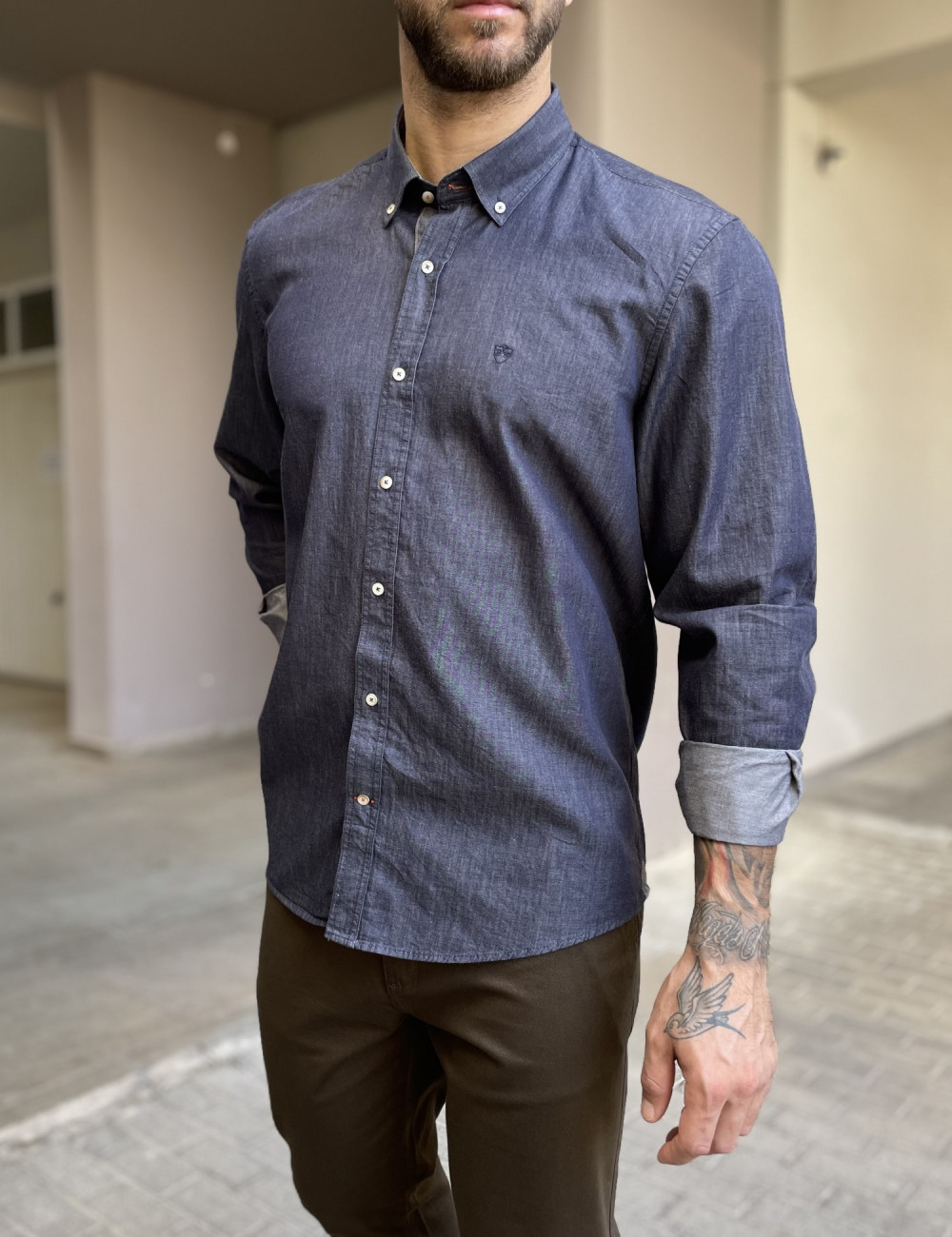 Ανδρικό πουκάμισο με denim όψη που διαθέτει γιακά κολάρο, κλείσιμο με κουμπιά, έχει ανάγλυφο σχέδιο με το λογότυπο της εταιρείας πάνω στην τσέπη του στήθους.