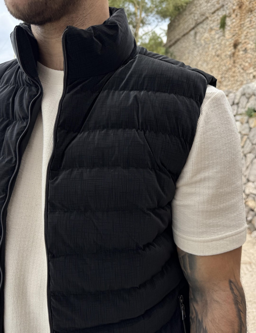 Ανδρικό καπιτονέ αμάνικο μπουφάν με διακριτικό καρό μοτίβο.