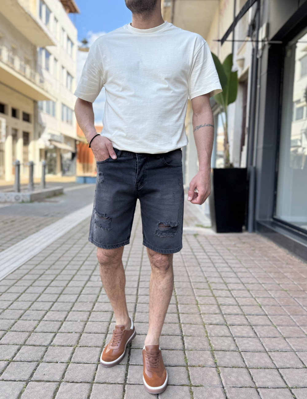 Ανδρική τζιν βερμούδα με σκισίματα.