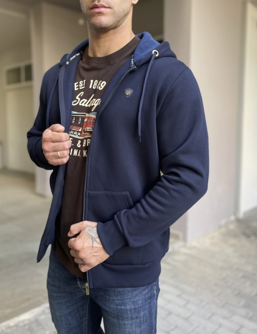 Ανδρική μονόχρωμη, βαμβακερή ζακέτα-φούτερ με κουκούλα και λάστιχο στα τελειωματά της για καλύτερη εφαρμογή.